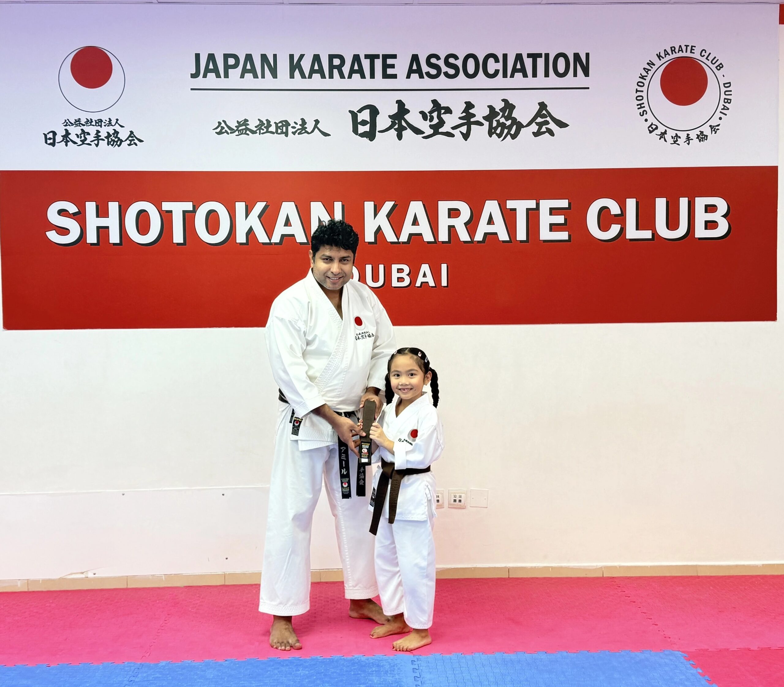 Student receiving a karate belt from Sensei Ameer at Shotokan Karate Club Dubai