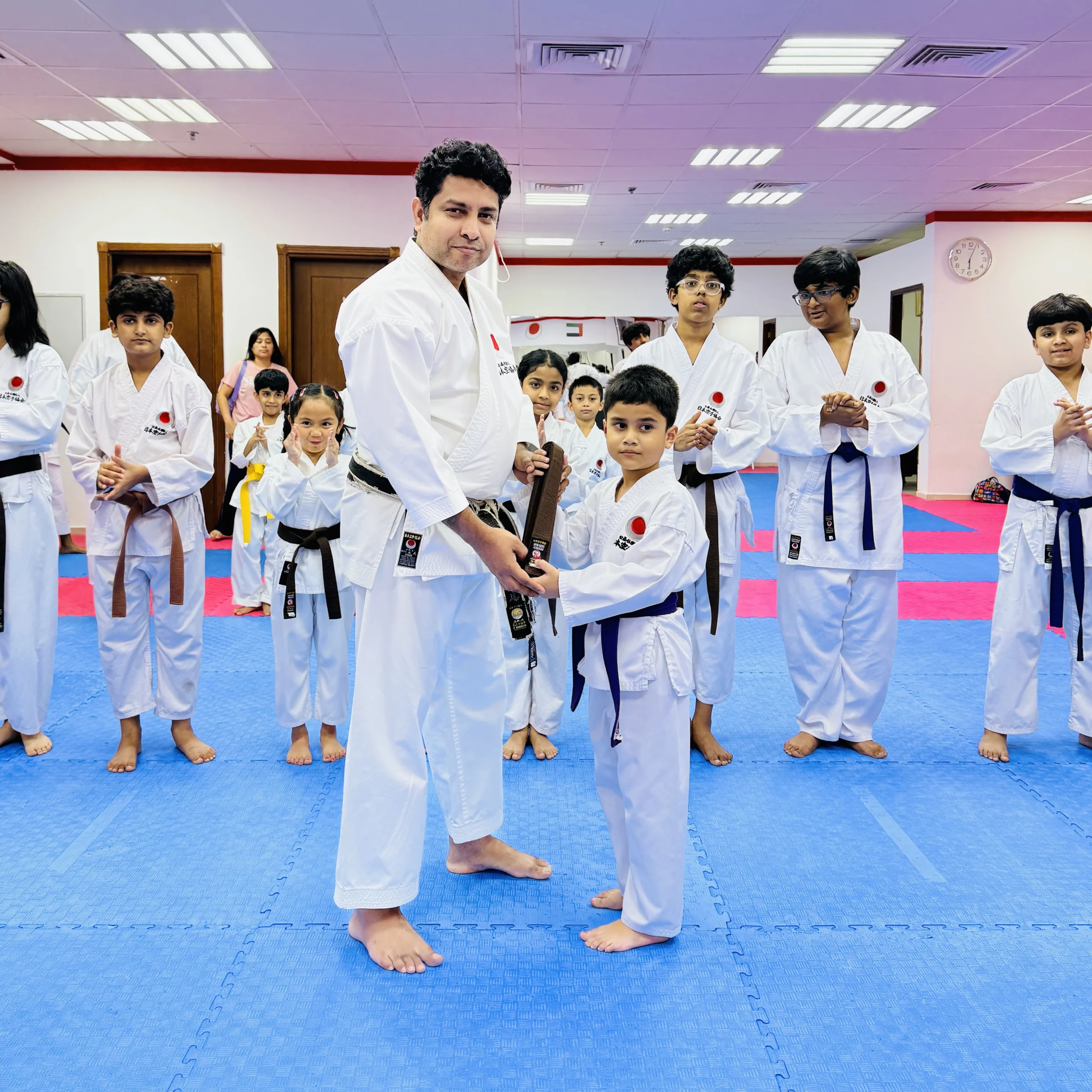 Student receiving a karate belt during the belt awarding ceremony at Shotokan Karate Club Dubai
